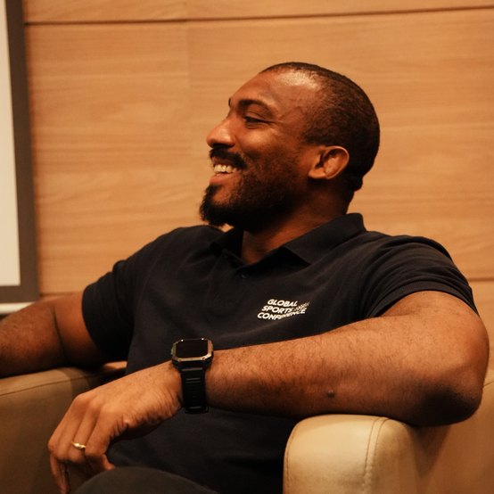 Pedro Bombom sorrindo, sentado numa poltrona
